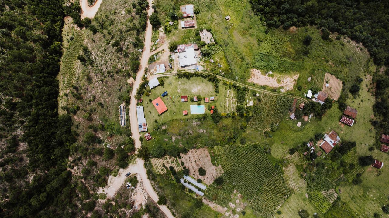 Aerial view of a rural landscape in San Bartolo, Totonicapán, showcasing homes, fields, and greenery.