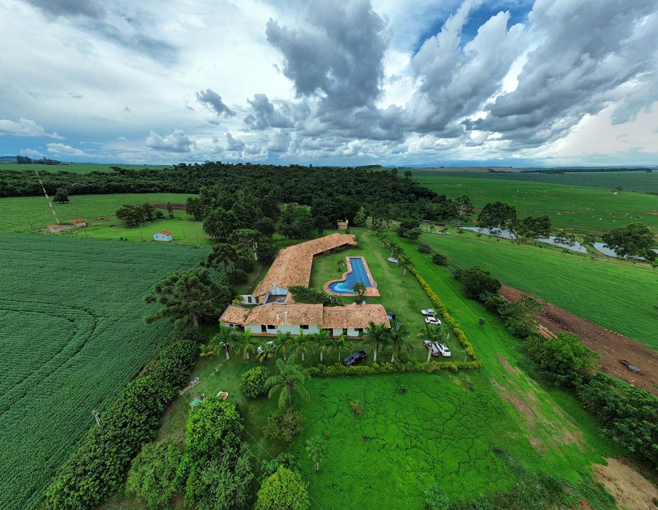 Aerial view of a countryside estate with pool and lush fields in Brazil.
