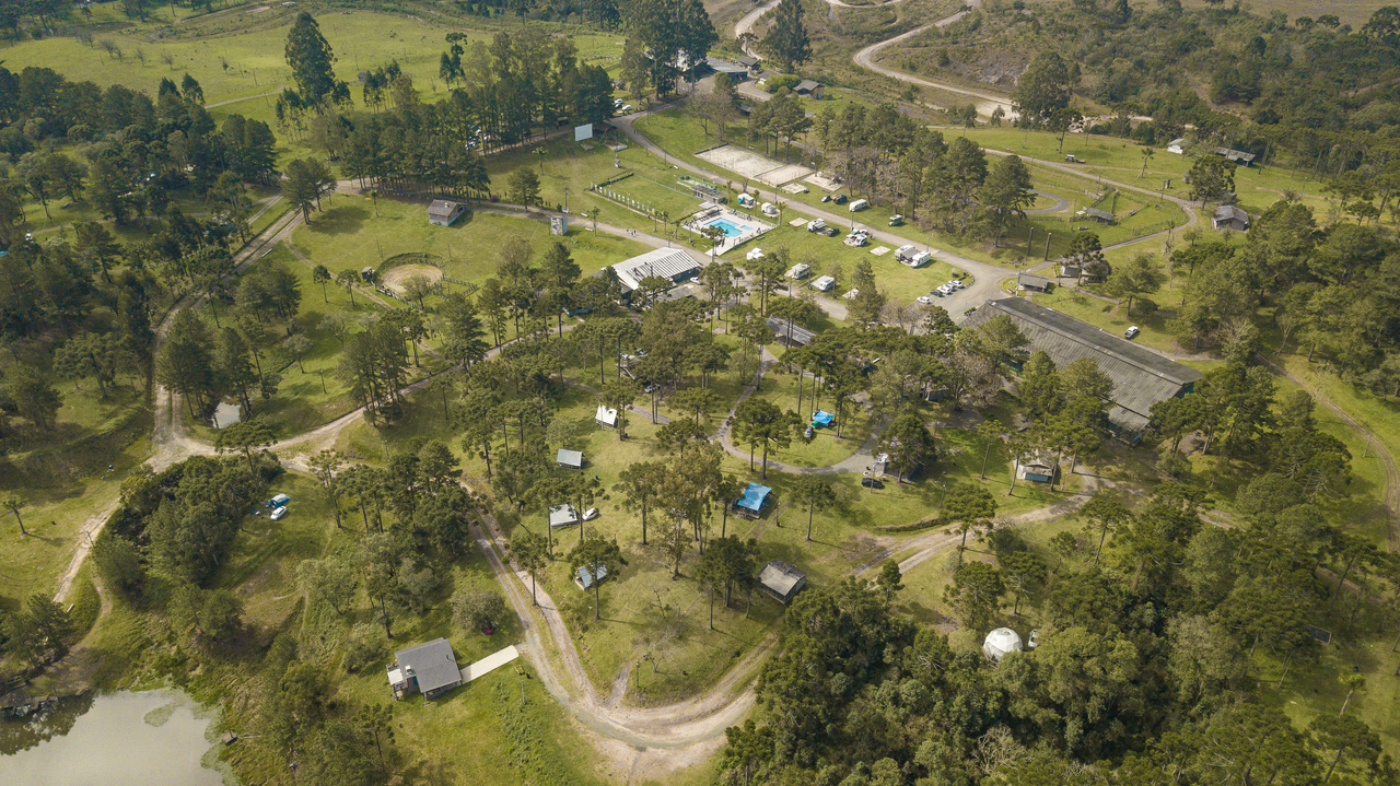 Aerial view of a peaceful countryside camping site with lush greenery.